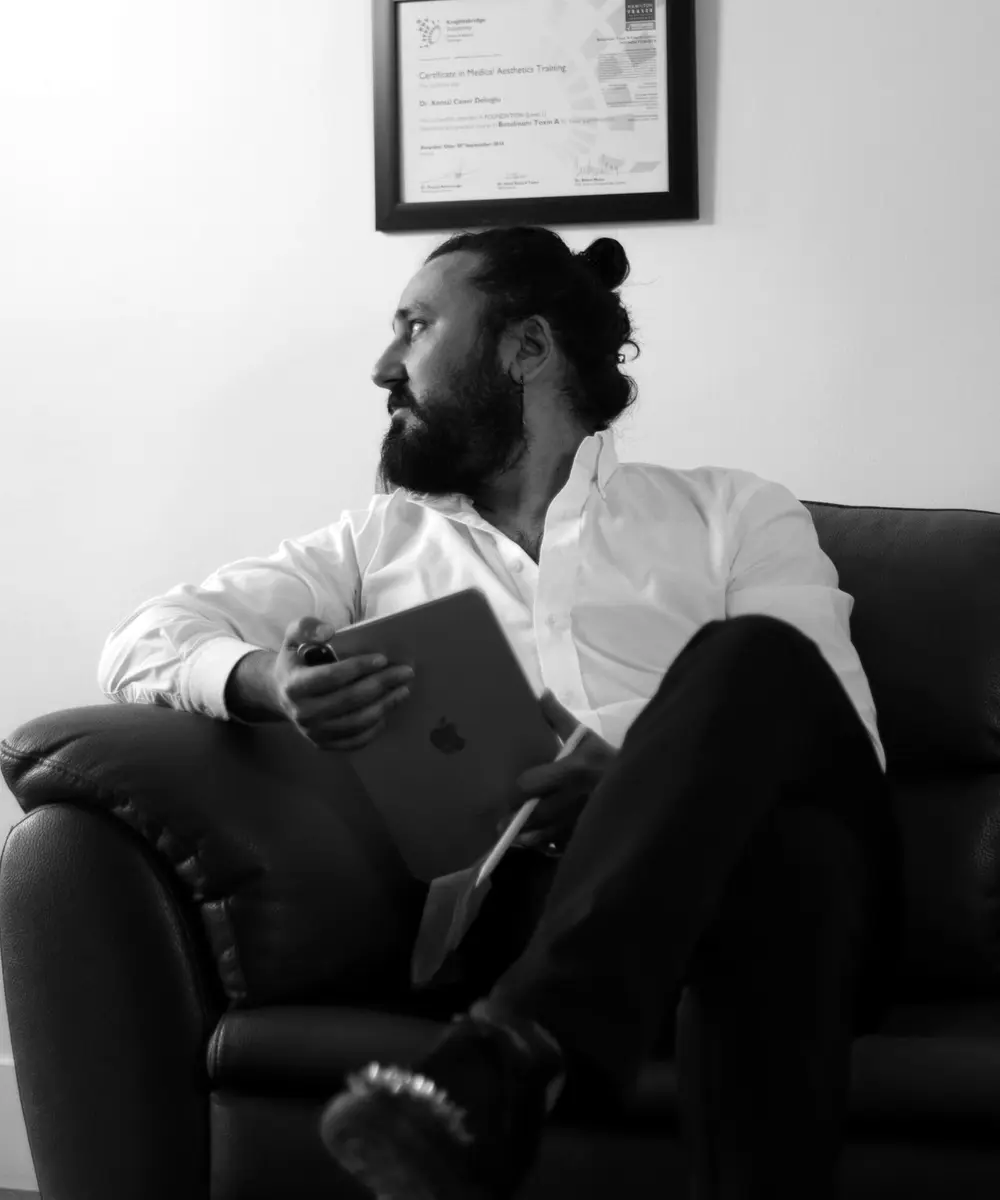 Op. Dr. Kemal Caner Delioğlu muayenehanesinde, elinde tabletle